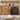 An informational graphic showing two wood-textured door options for a pet gate: a fluted fixed panel on the left and a scalloped arched metal door on the right, with labels and descriptive text on a softly blurred interior background.