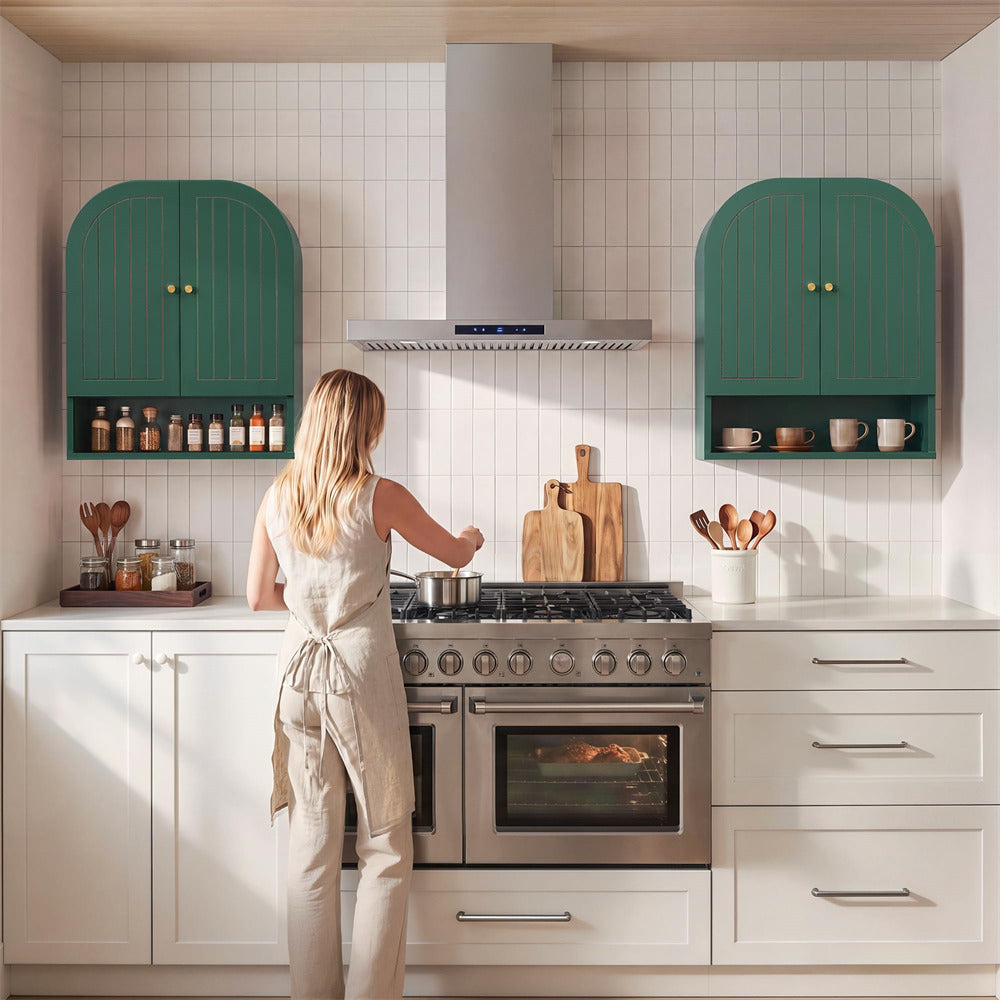 Woman cooking in a modern kitchen with green cabinets and white countertops.