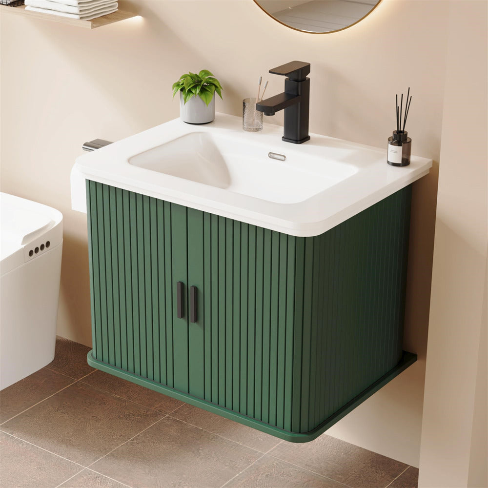 Green vanity unit with white sink and black faucet in a bathroom setting.