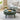 Green coffee table with a laptop, cup, and snacks in a living room setting.
