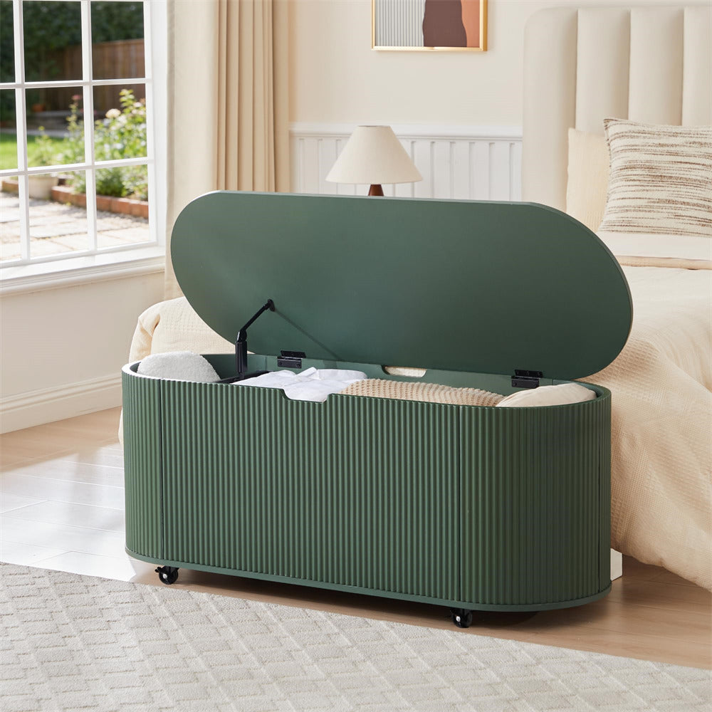 Green storage bench with open lid in a room with a window and lamp.