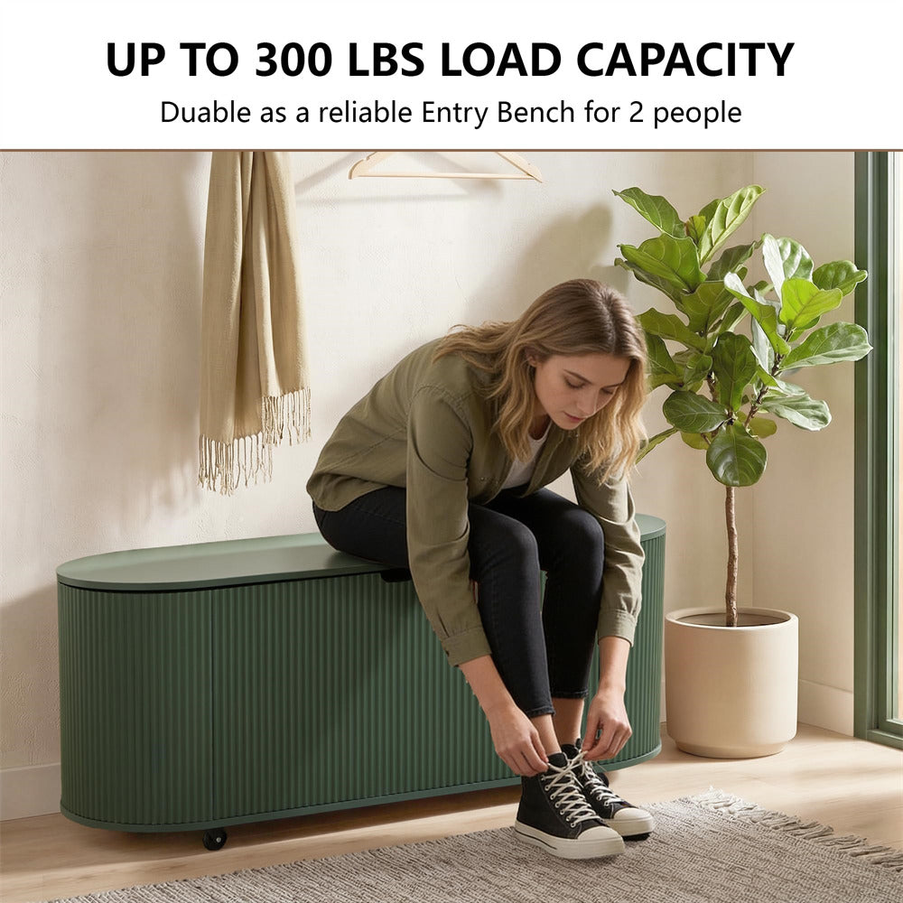 Woman sitting on a green storage bench tying her shoes in a room with a plant and coat.