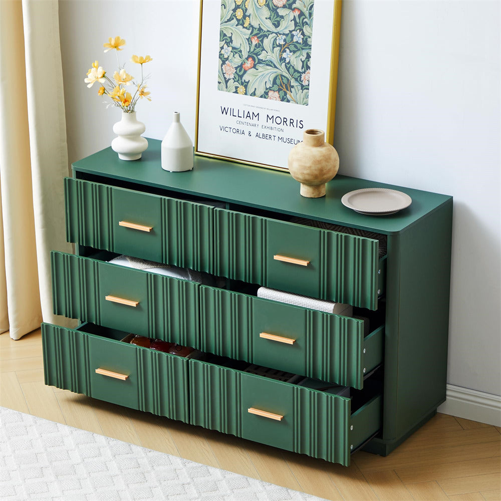 Green 6 drawers dresser with gold handles in a room setting with decor elements.