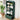 A dark green modular bookshelf with a rounded top, five open shelves, and a lower drawer, styled with books, boxes, and a small plant in a bright room.