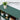 Green solid wood bookcase with decorative items on a white background