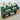 Green console table with two drawers, clock, and decorative items in a room.