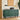 Green sideboard with decorative items in a room with a painting and plant.