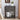 Decorative grey nightstand with books, a vase of flowers, and a coffee cup on a light gray wall background.