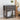 Decorative grey nightstand with embossed design, books, and a vase in a bedroom setting.