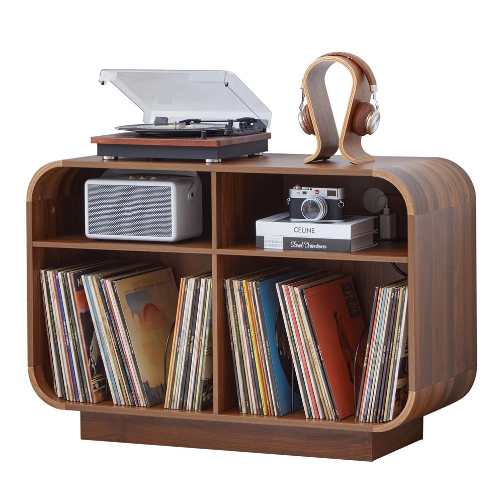 A wooden record player shelf with curved sides and four open shelves, styled with vinyl records, a turntable, headphones, a speaker, books, and a camera, on a white background.
