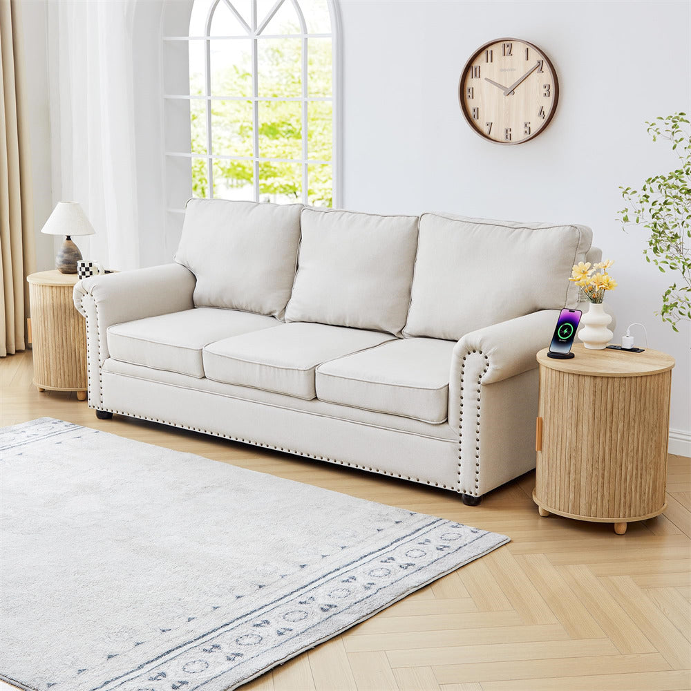 Beige sofa in a living room with a clock on the wall and a side table.