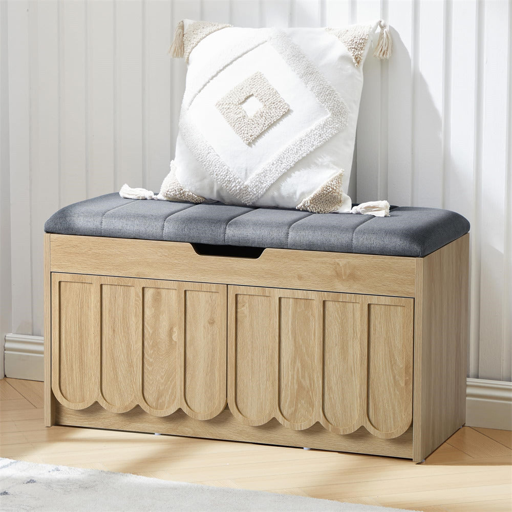 Wooden shoe storage bench with a gray cushion and decorative pillow in a room setting.