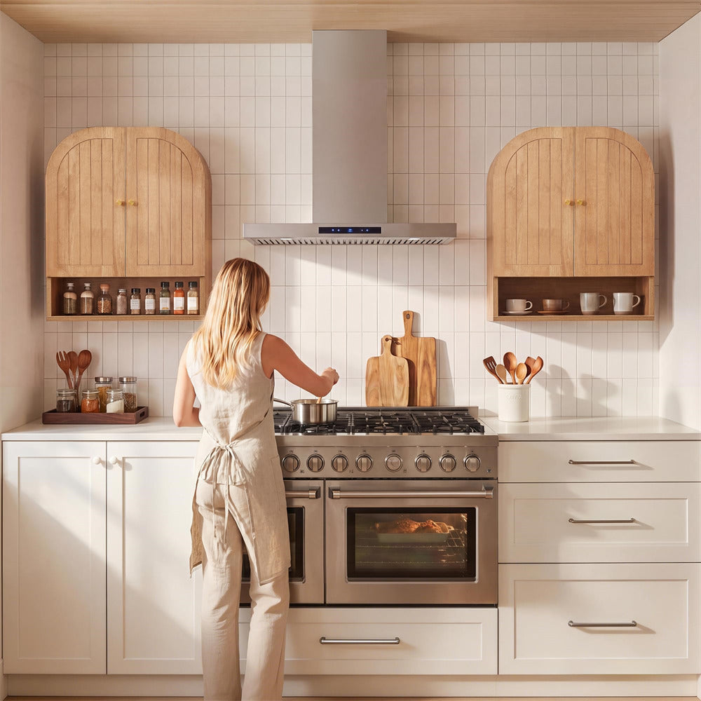 Woman cooking in a modern kitchen with wooden cabinets and white tiled walls.