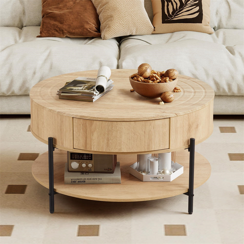 Round wooden coffee table with a bowl of nuts and magazines on top, in front of a beige sofa.