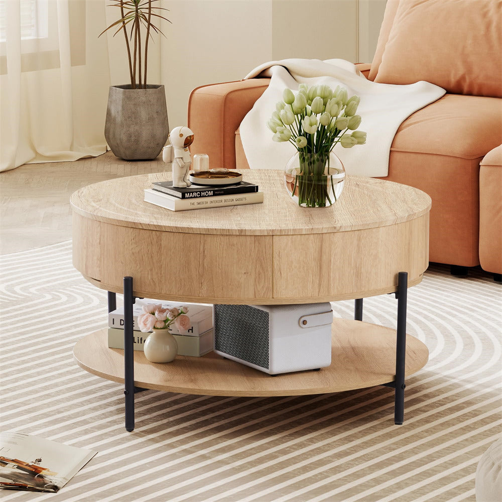 Round wooden coffee table in a living room with books, a vase, and decorative items.