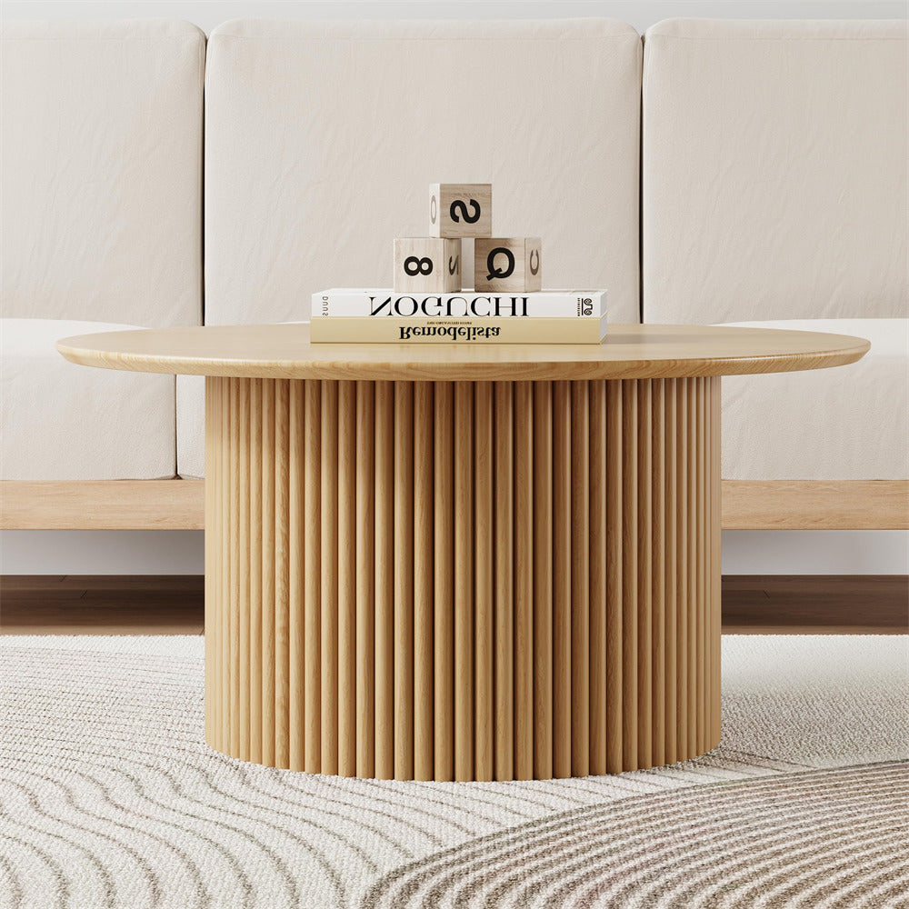 Wooden coffee table with a textured cylindrical base in a living room setting.