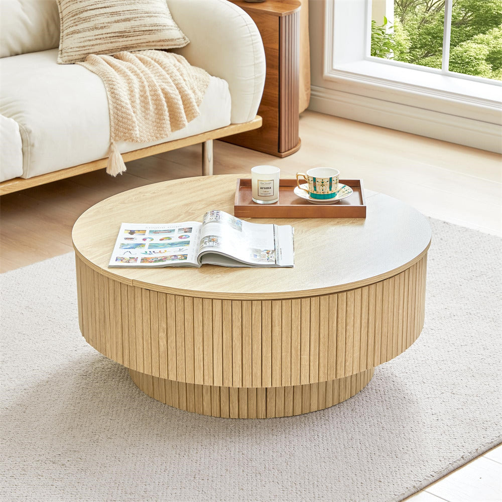 Round wooden coffee table in a living room with a magazine and tray on top.