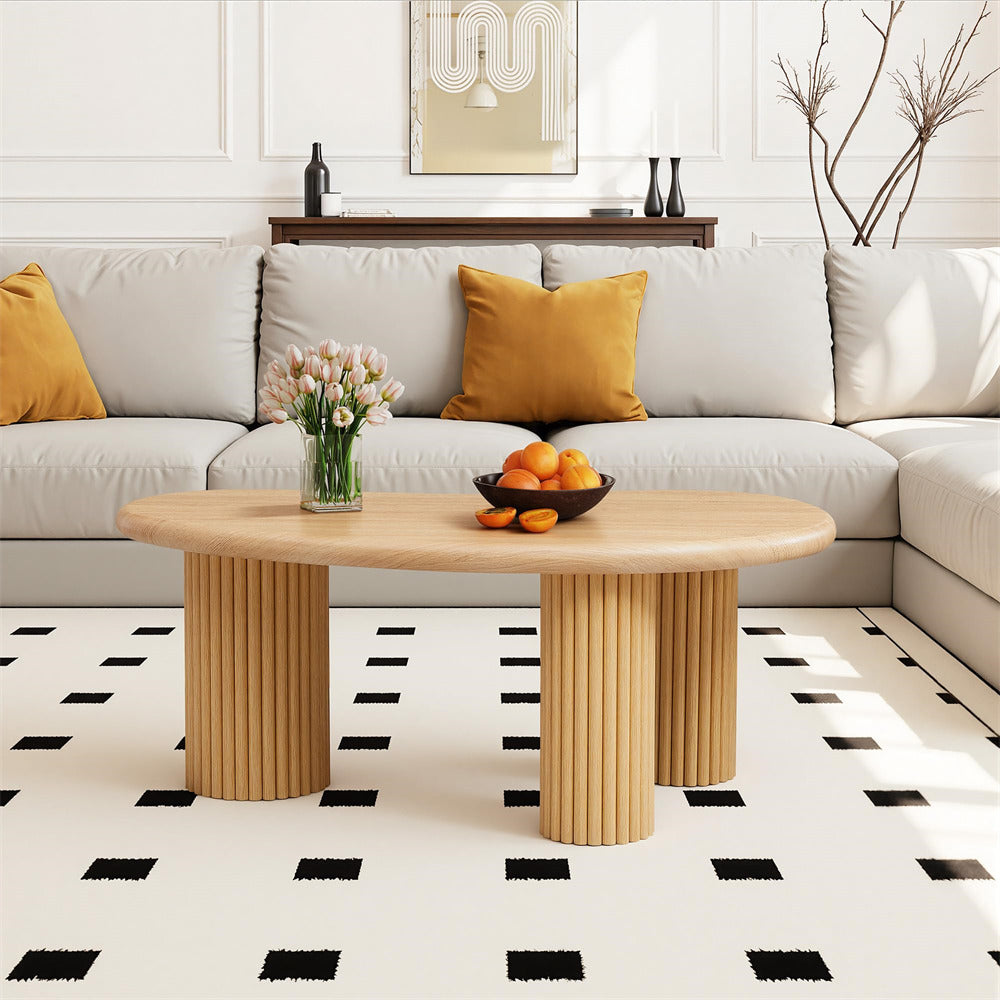 Modern living room with a sectional sofa, coffee table, and decorative elements.