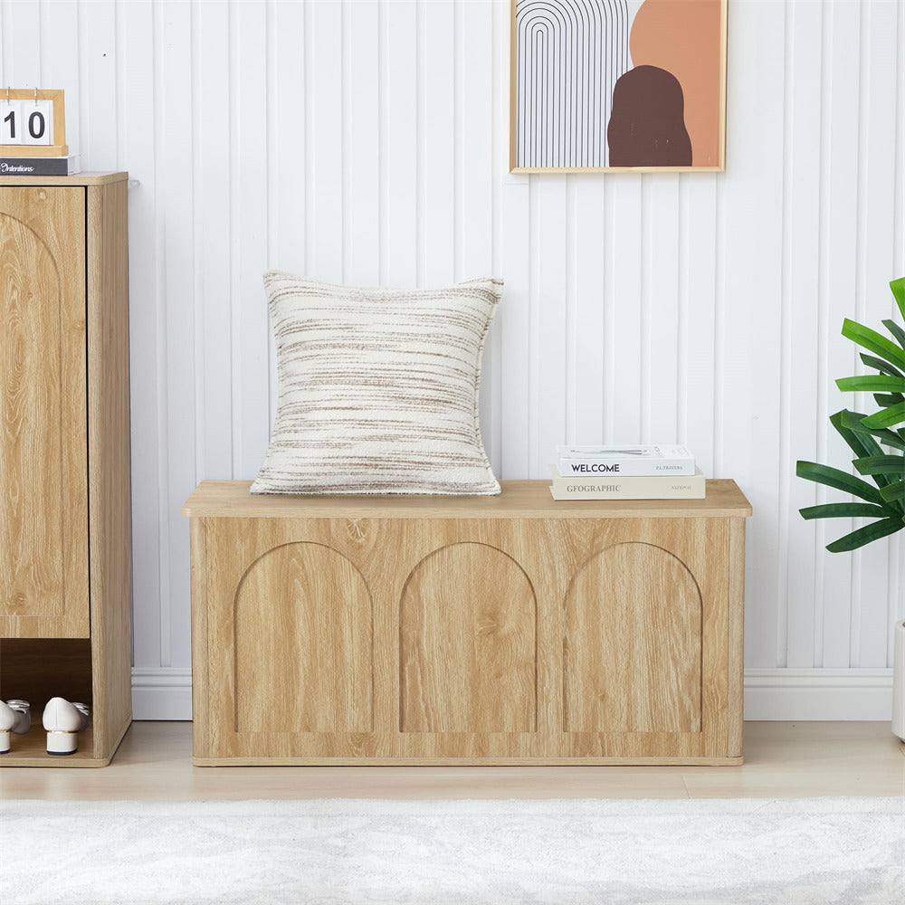 Wooden bench with decorative pillow and books in a room with a plant and framed art on the wall.