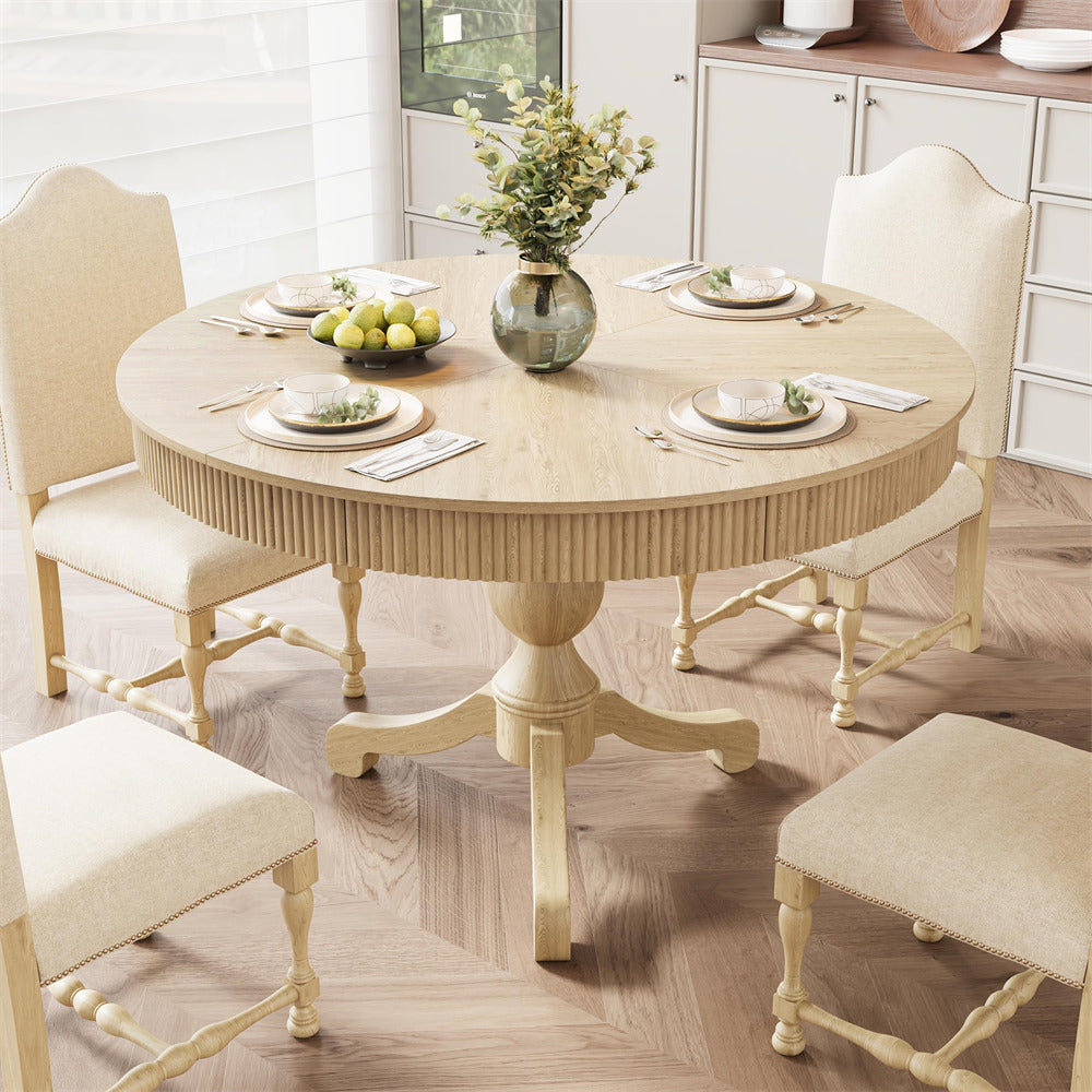 Round wooden dining table with chairs in a bright room