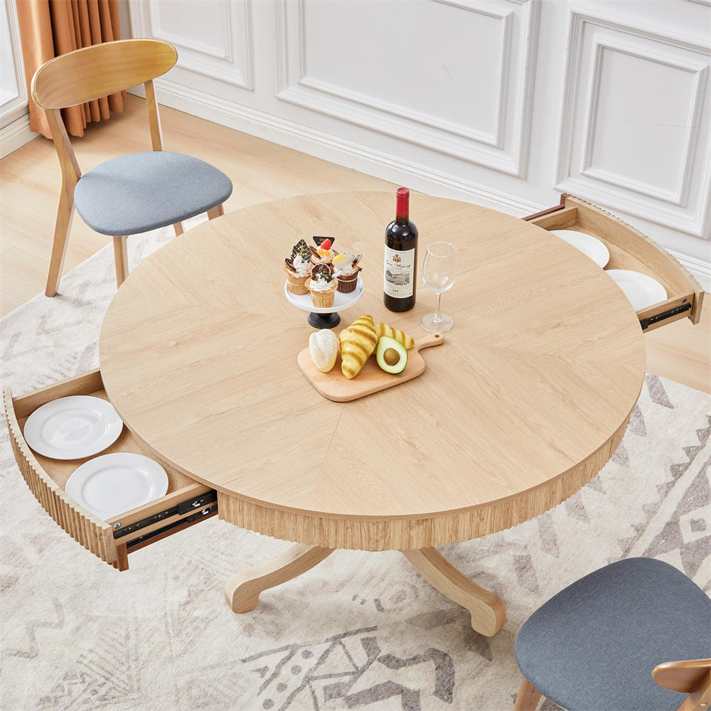 Round wooden table with extendable drawers in a room with chairs and decor.