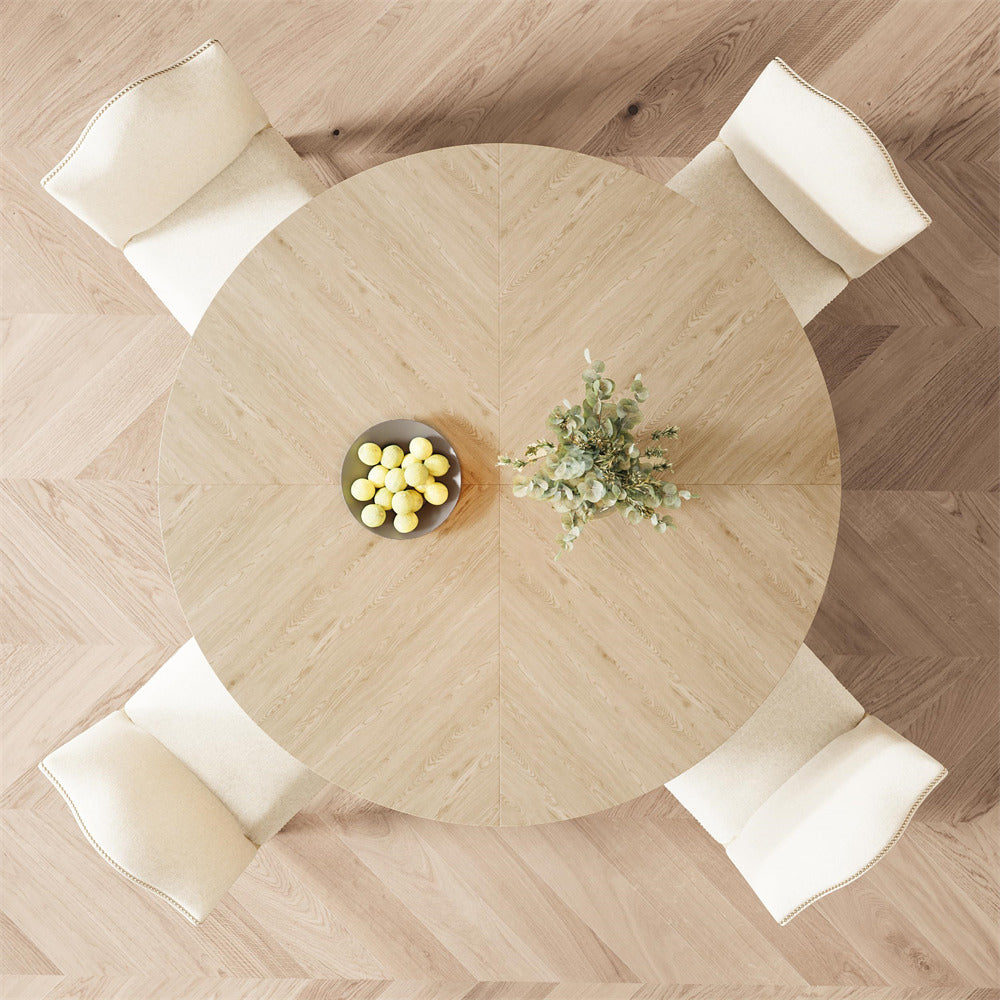 Round wooden table with decorative items in a room with wooden flooring.