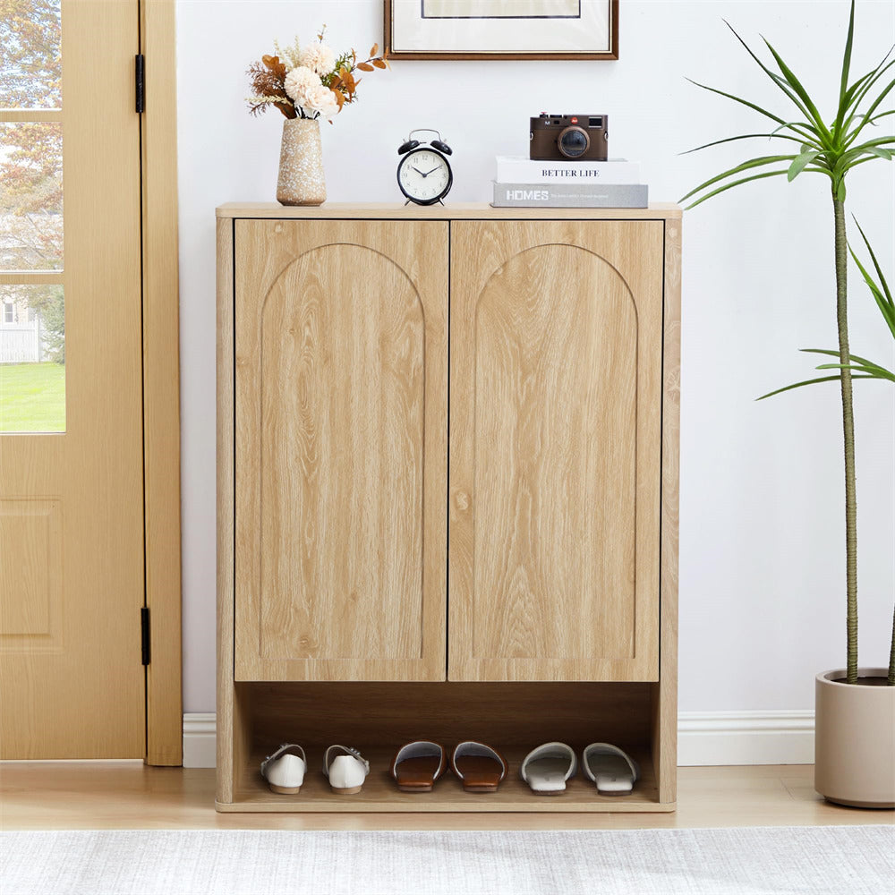 Wooden shoe cabinet with shoes inside, placed in a room with a plant and a door.