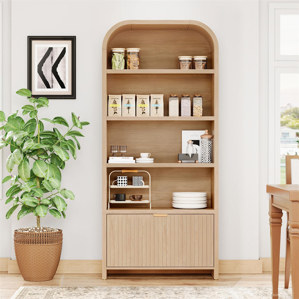 Wooden bookshelf with decorative items in a room with a plant and table.
