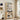 Wooden bookshelf with decorative items in a room with a window and plant.