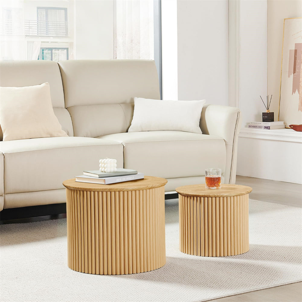 Two round wooden side tables in a living room setting with a beige sofa.