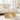 Two round wooden side tables in a living room setting with a beige sofa.
