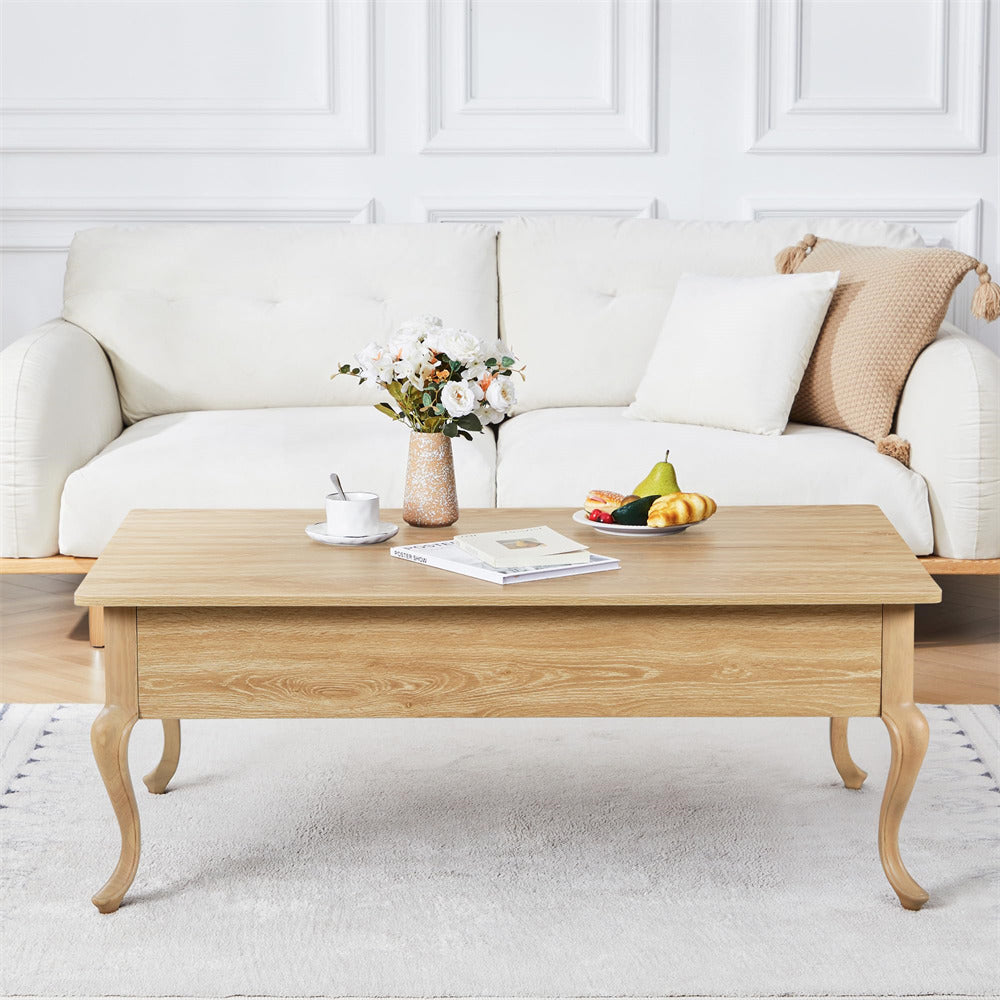 Wooden coffee table with a vase of flowers, fruit plate, and newspaper in a living room setting.
