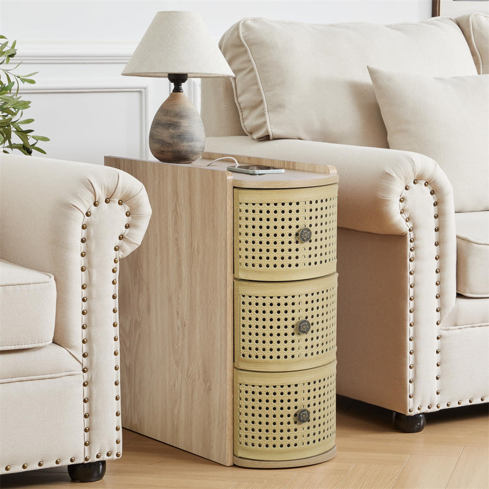 Light wood side table with woven drawers next to a beige sofa and armchair in a living room.