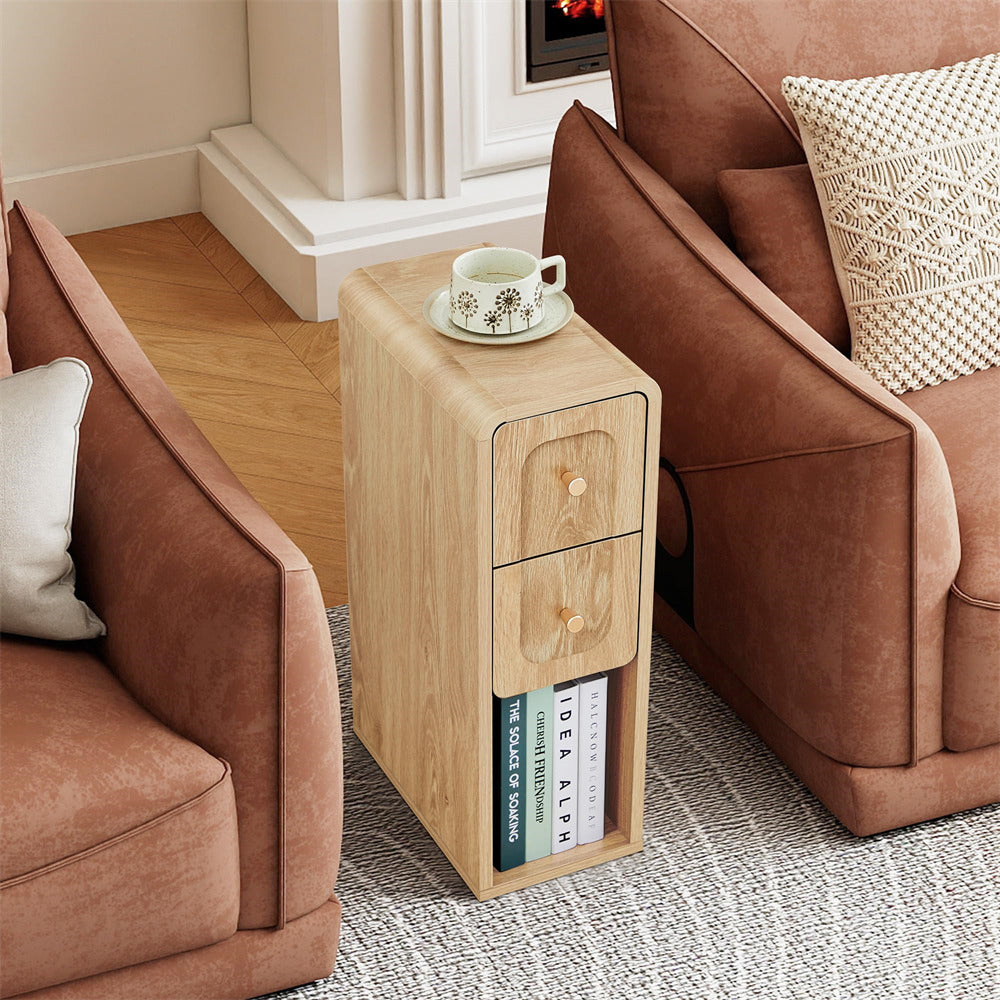 Wooden side table with books and a cup between two brown sofas.