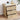 Wooden nightstand with multiple drawers, books, and decorative items on a light wooden floor.