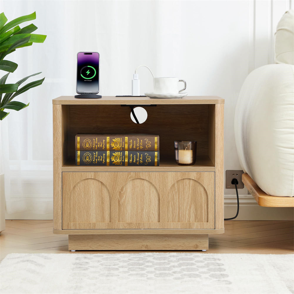 Wooden side table with books, a candle, and a smartphone in a living room setting.