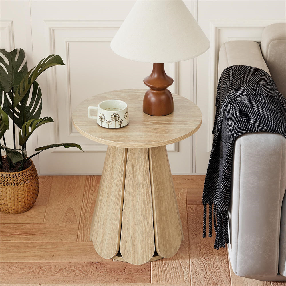 Wooden side table with a lamp and mug next to a sofa in a living room.