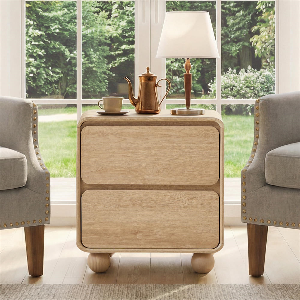 Wooden side table with a lamp and tea set in a room with large windows and chairs.