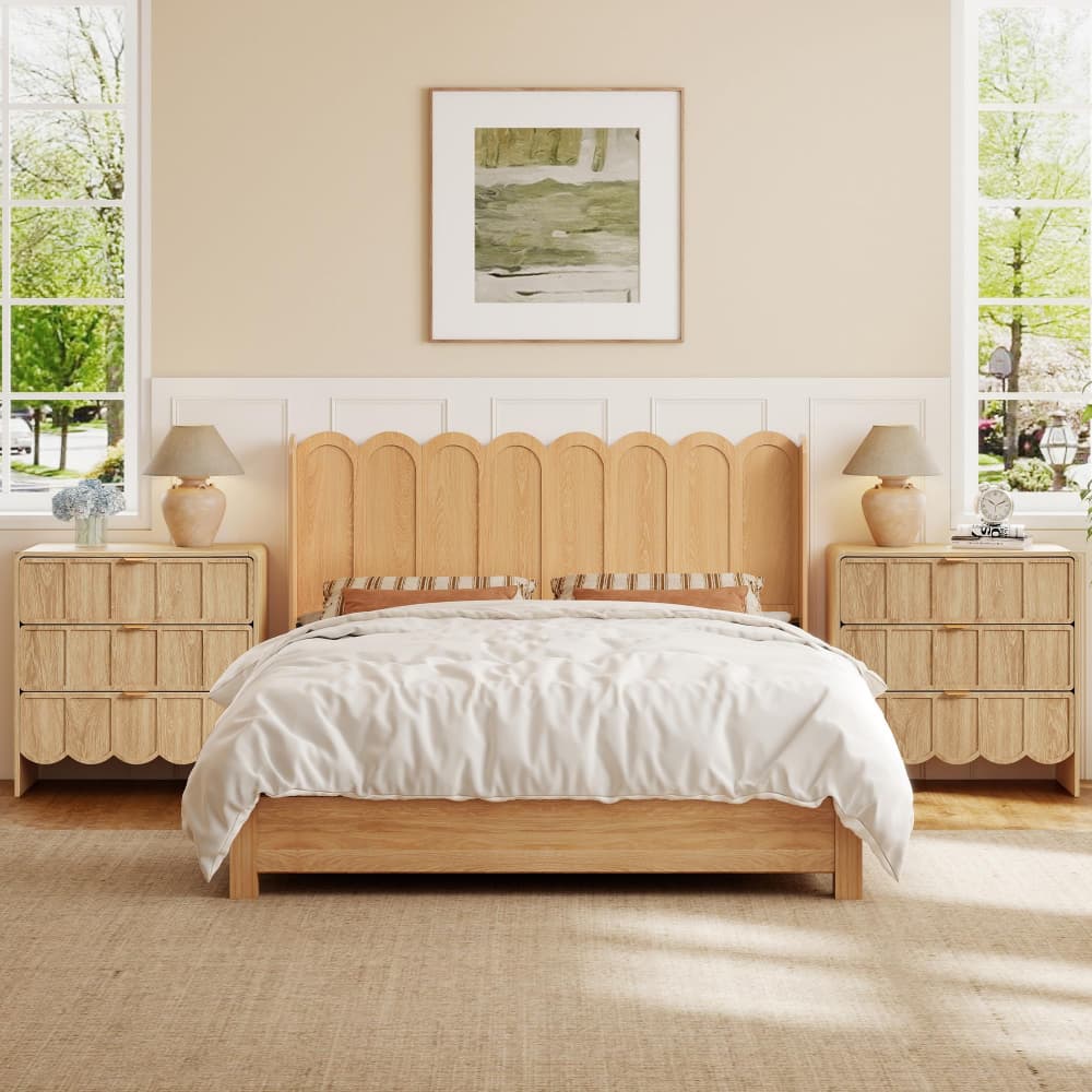 A light natural wood bed frame with a scalloped headboard, styled in a bright bedroom with matching nightstands, bedside lamps, and white bedding.