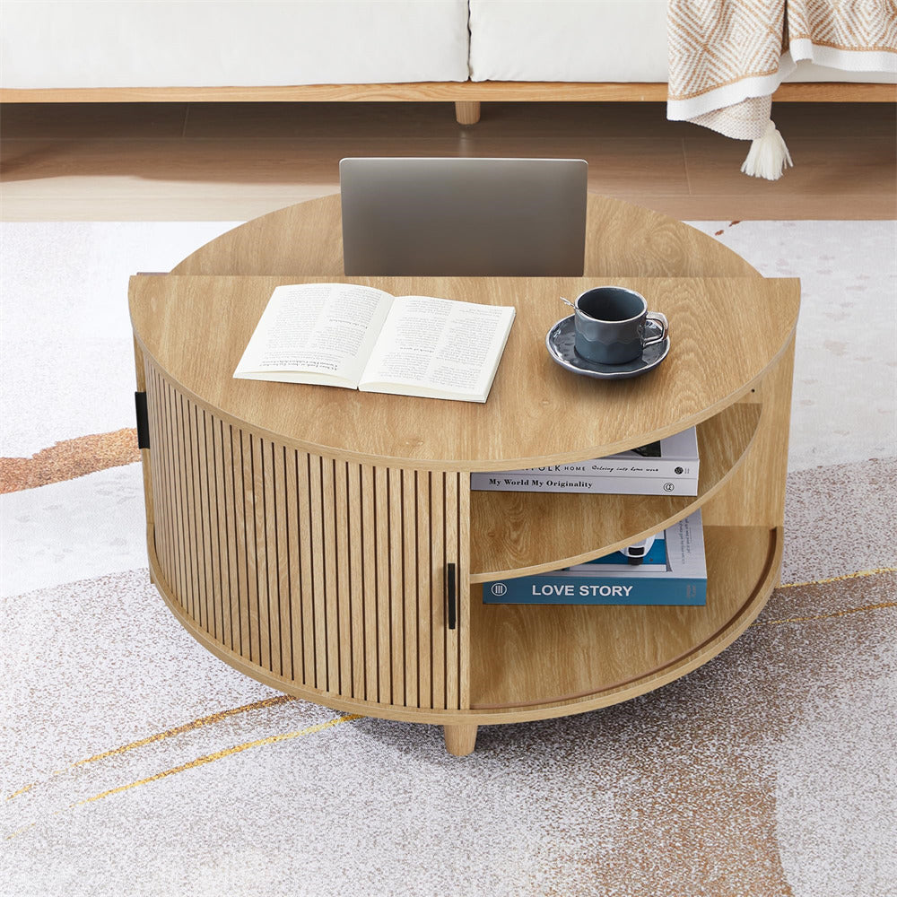 Round wooden coffee table with books and a cup on a light-colored floor.
