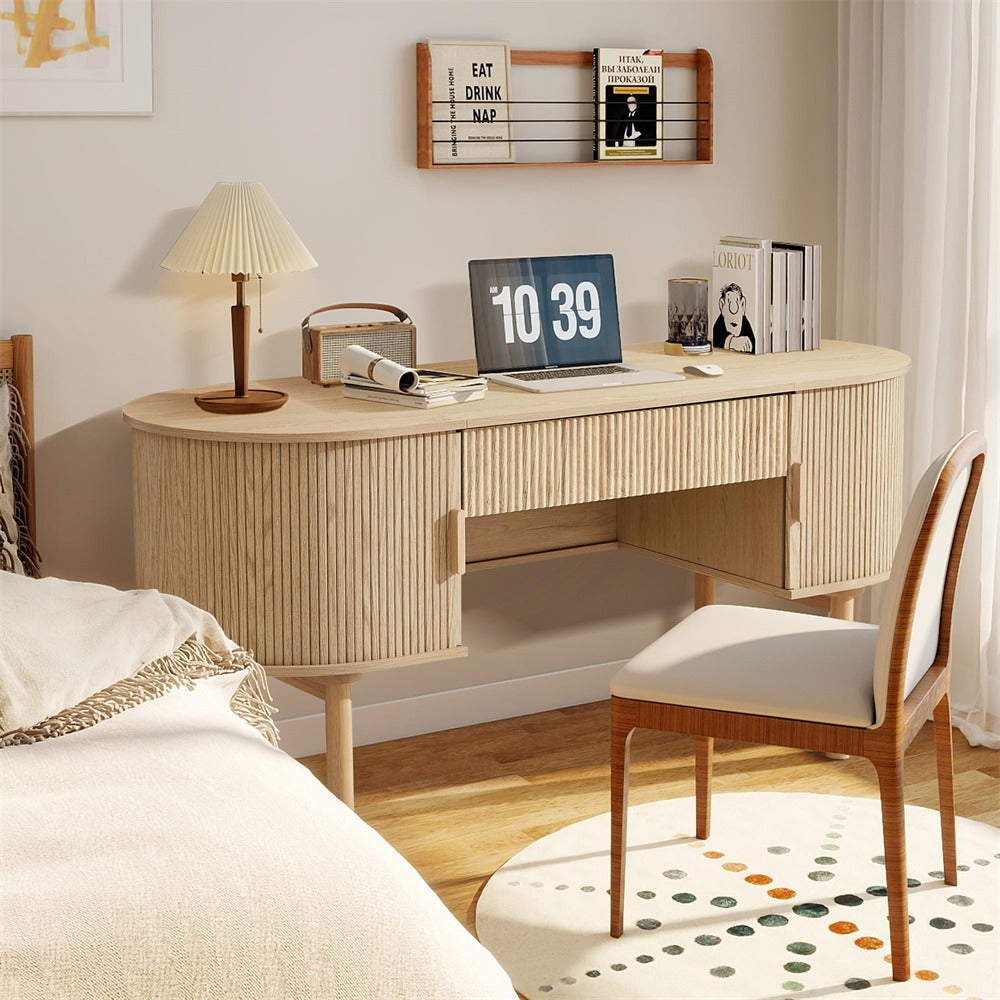 Wooden desk in a bedroom with a laptop, books, and a lamp.