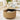 A round lift-top coffee table in a warm light wood finish, styled in a bright living room. The table features a fluted slatted lower body with a scalloped edge, a black metal trim, and a lift-up top surface holding a laptop and flowers.