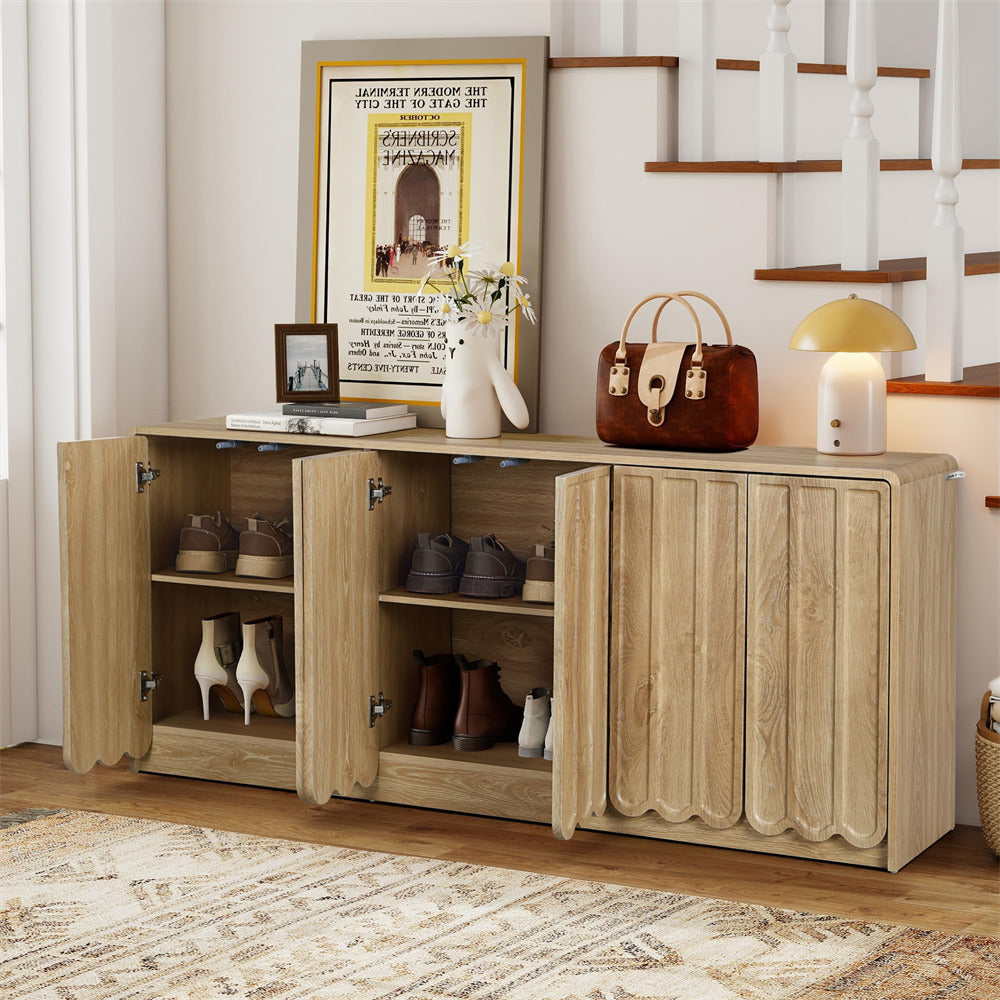 Wooden sideboard with open doors displaying shoes and decor items, framed picture on wall.