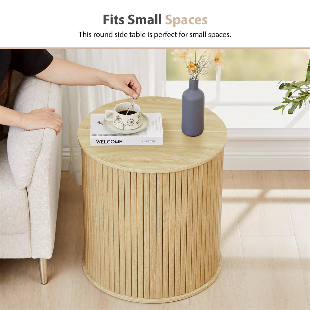 Round wooden side table with a cup of coffee and a vase in a living room setting.