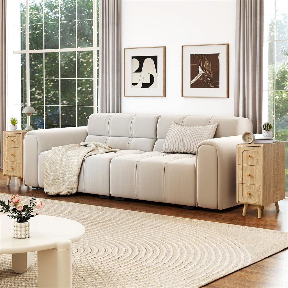 Beige sectional sofa in a living room with wooden side tables and abstract art on the wall.