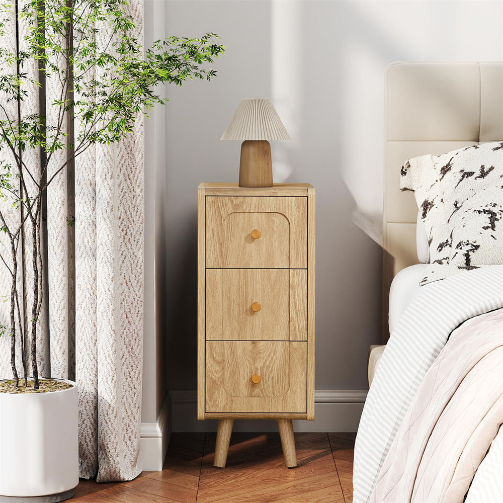 Wooden nightstand with two drawers next to a bed in a bedroom setting.