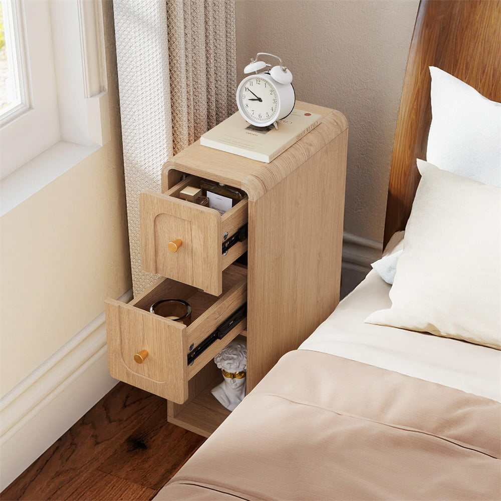 Wooden nightstand with open drawer next to a bed with pillows