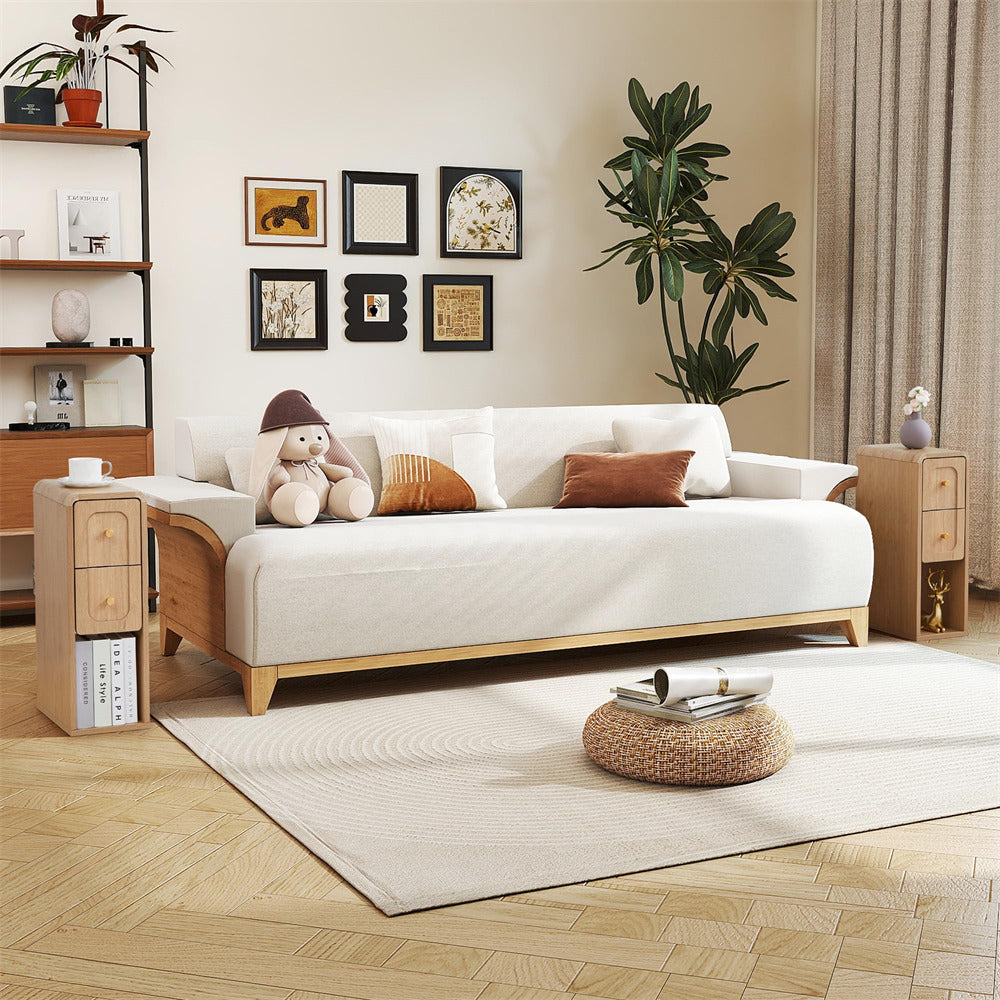 A modern light wood daybed with a white upholstered seat, styled in a warm, minimalist living room with a beige rug, wooden side tables, and framed wall art.