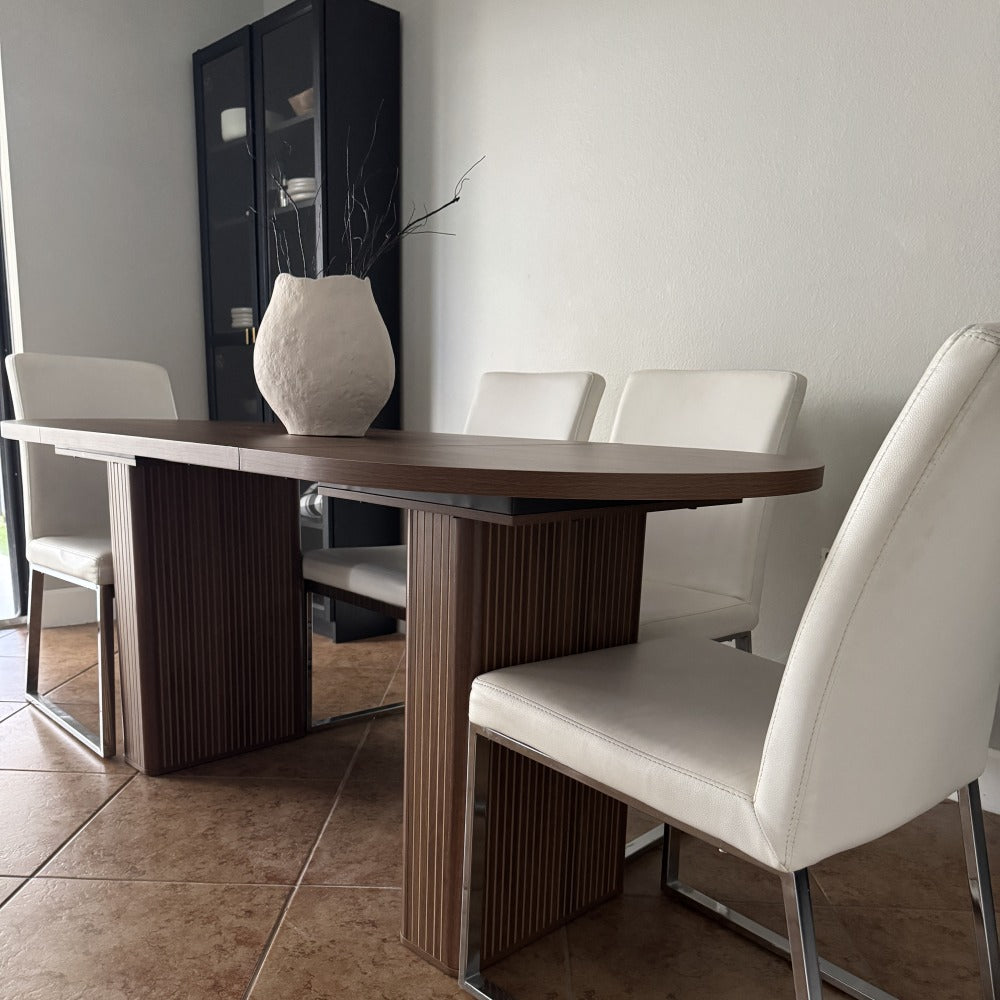 Dining room with a wooden table and white chairs.