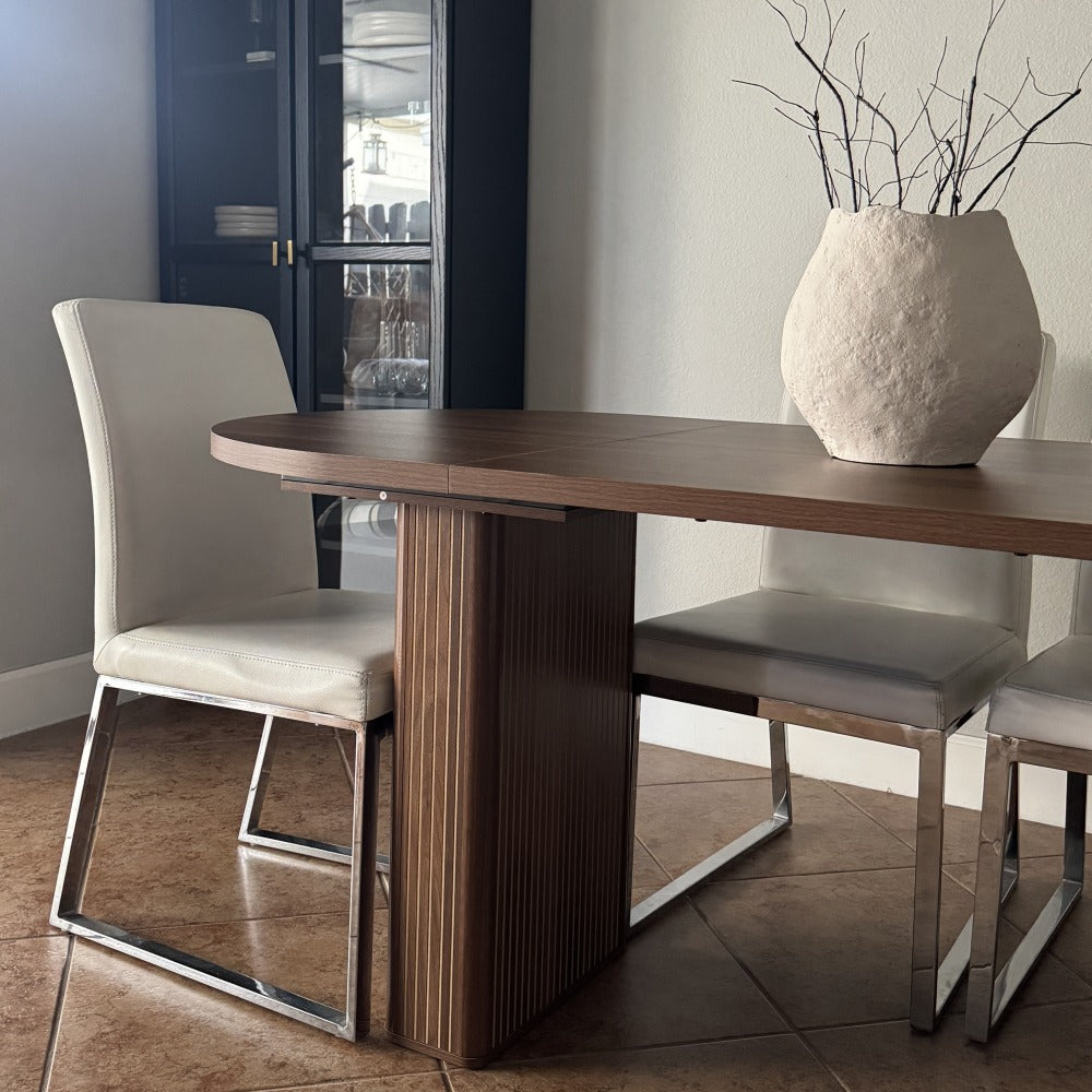 Dining table with chairs and a vase in a modern interior setting